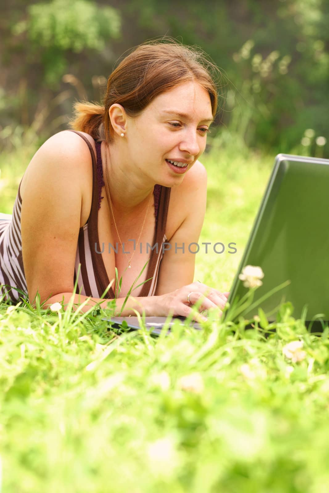 Young woman using her laptop outdoors. by romanshyshak