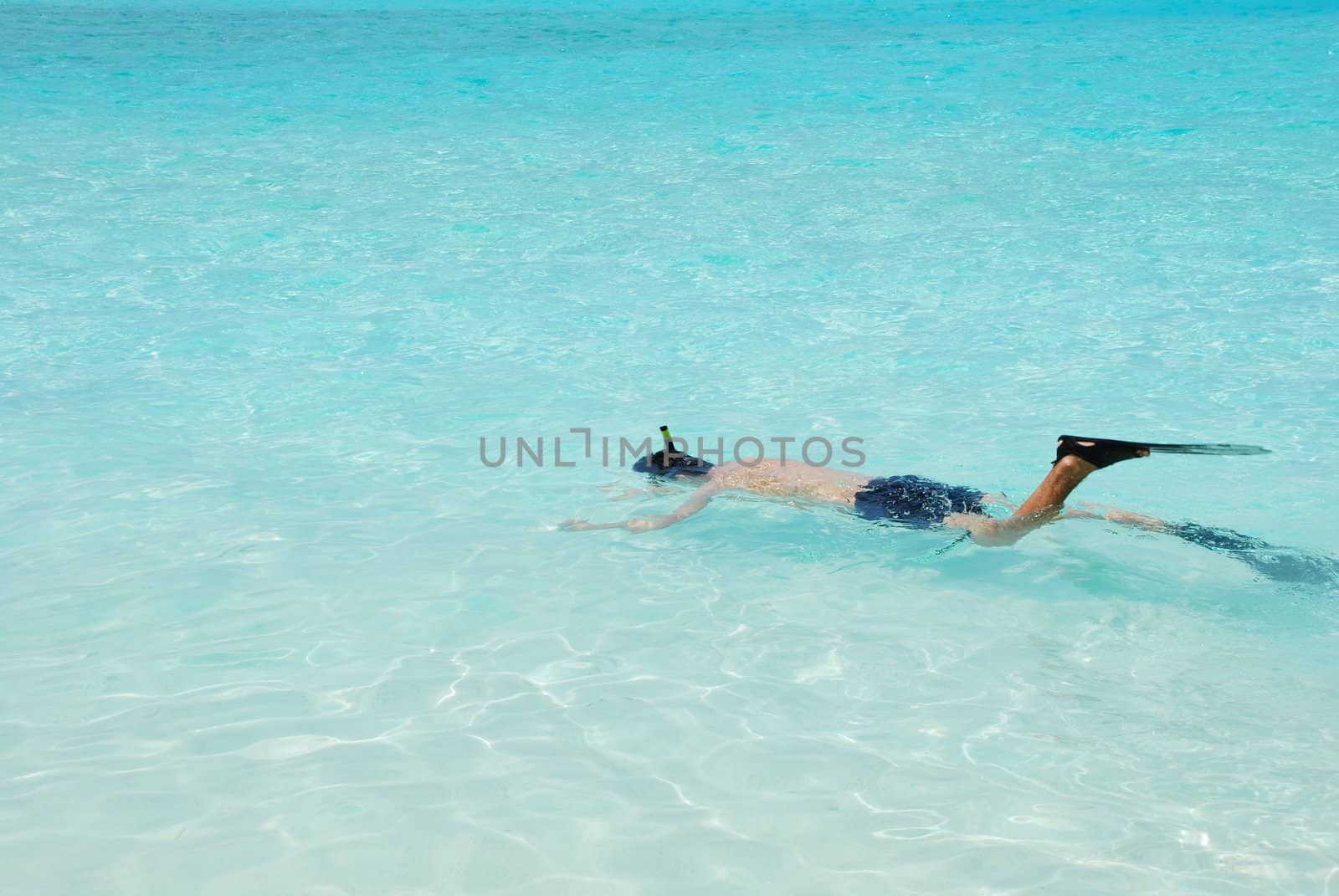 Young man snorkeling in Maldives (blue ocean water) by luissantos84