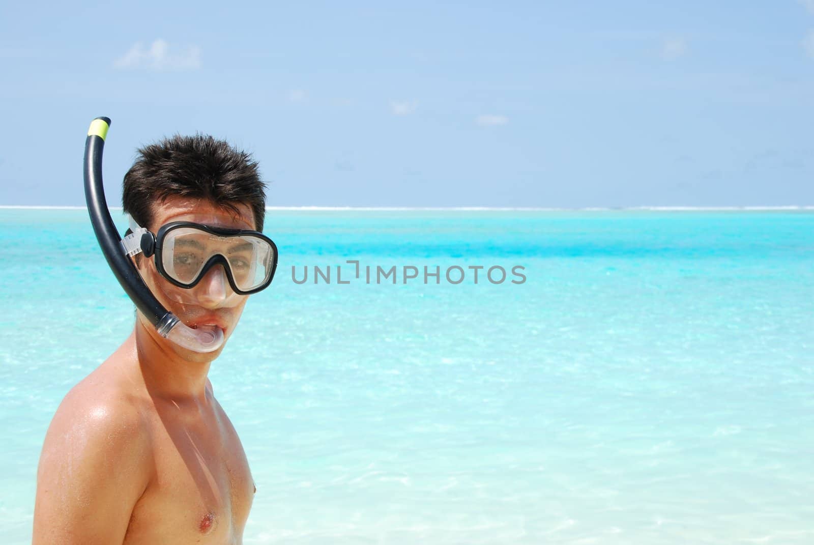 Young man ready to go snorkeling (blue ocean background) by luissantos84