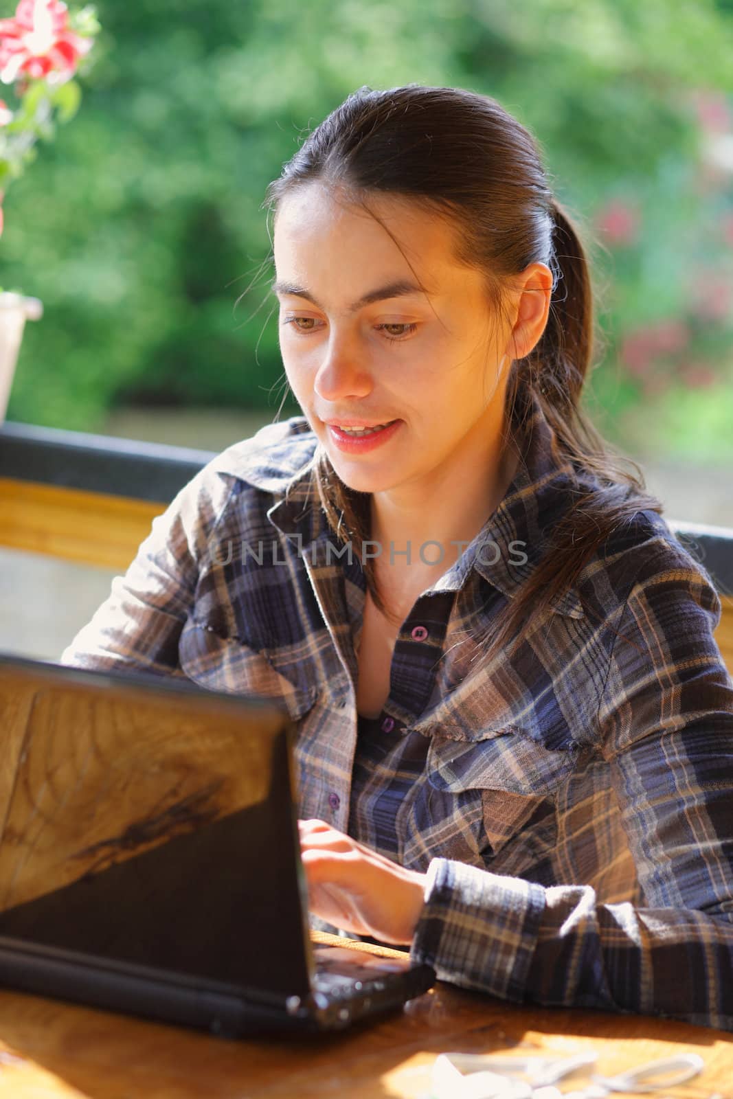 Young woman using her laptop outdoors. by romanshyshak