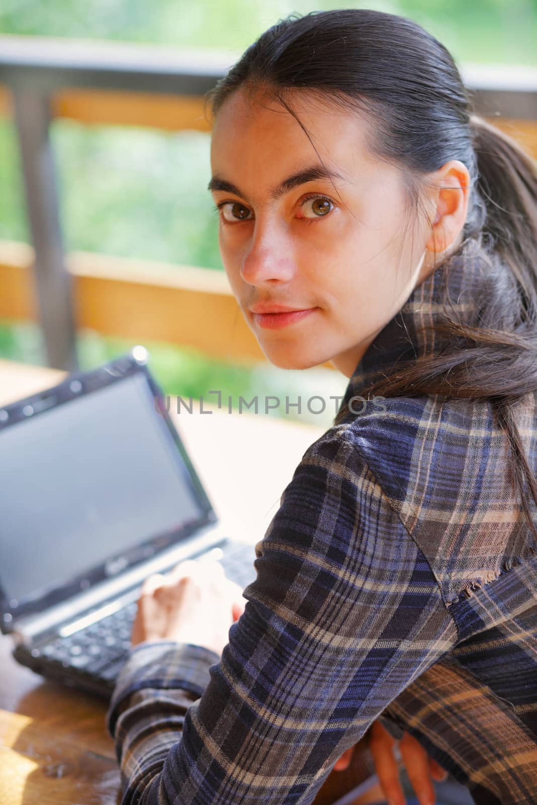 Young woman using her laptop outdoors. by romanshyshak