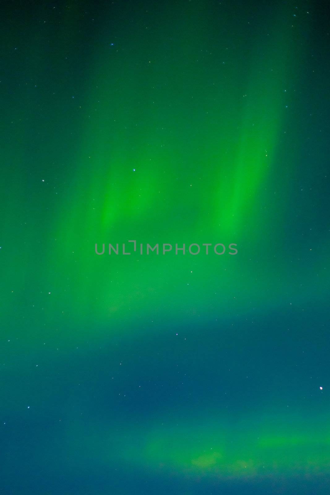 Clear night sky with lots of stars and dancing northern lights (Aurora borealis).