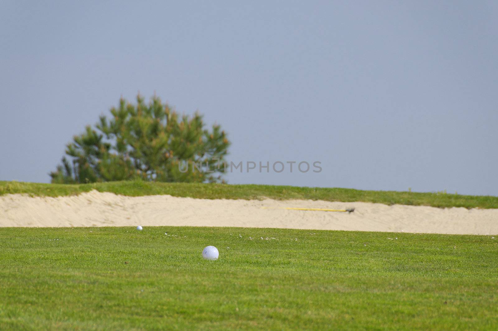 two ball of golf near a sand bunker