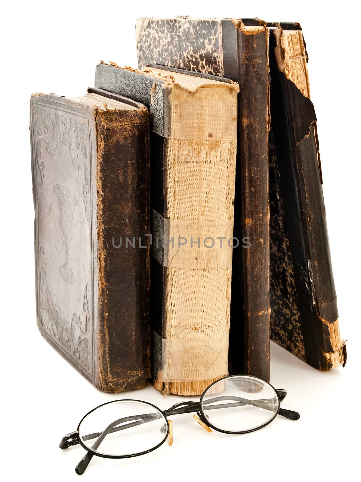 old books and glasses near it against white background 