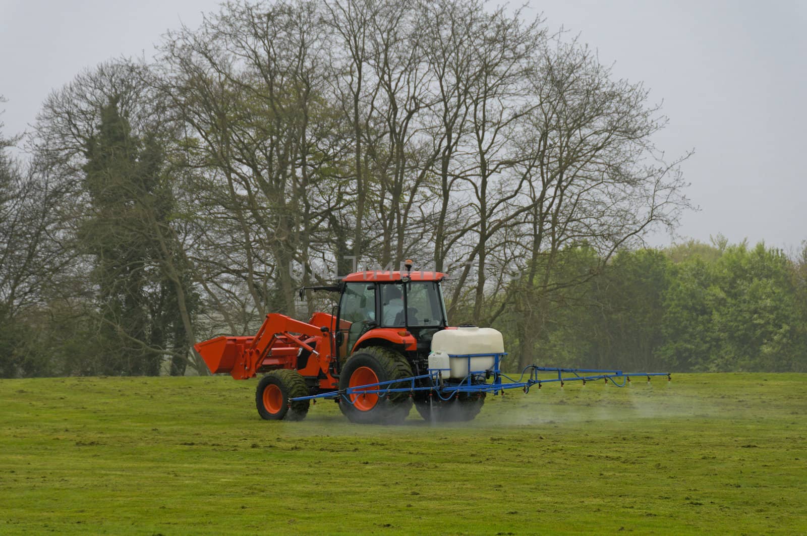 a red tractor spreads of the product on the grass