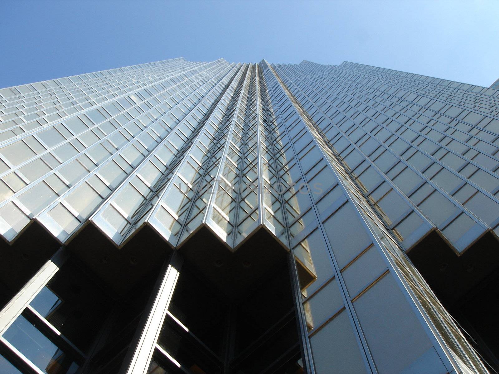 Modern building viewed from down with windows in glass and many angles by beautiful weather