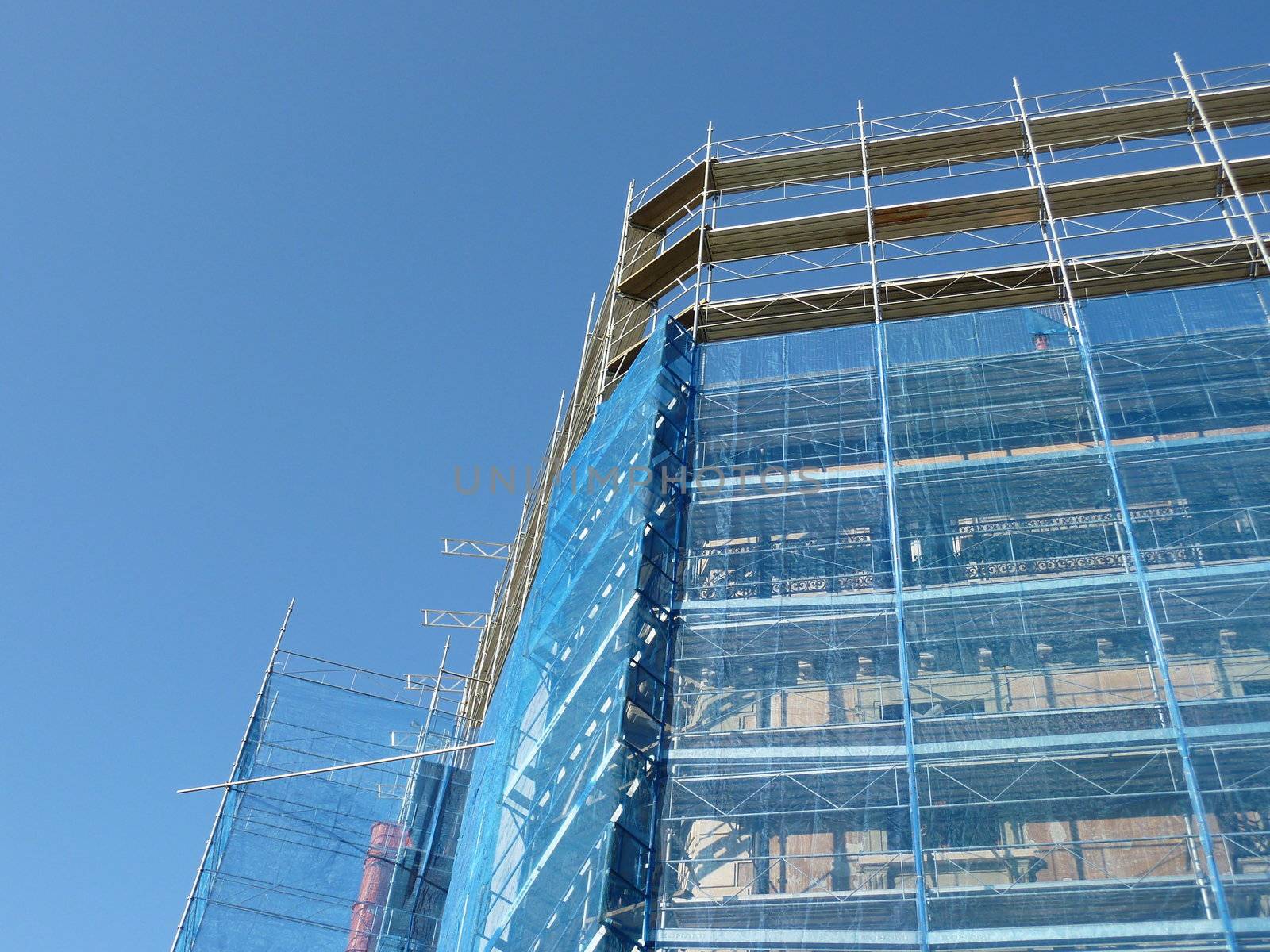 Side of scaffolding on building by beautiful blue sky