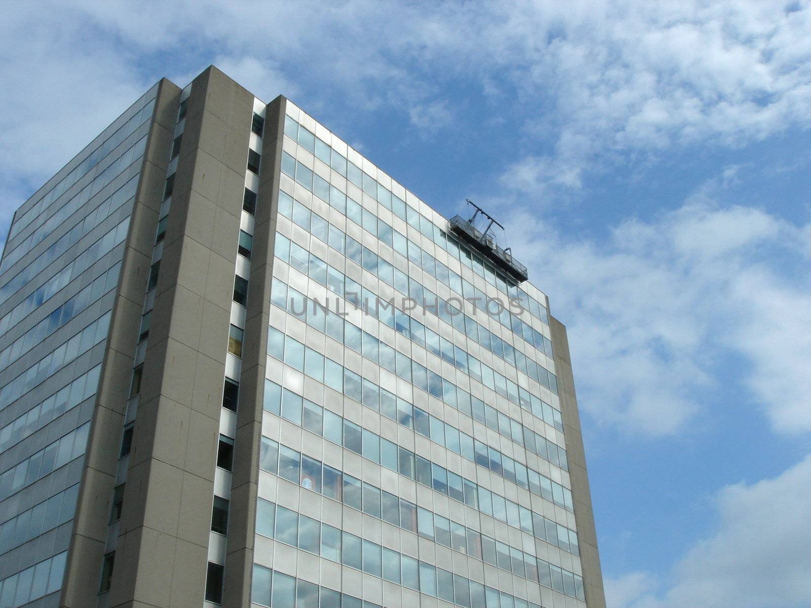 Modern building with cleaner on the top and cloudy sky