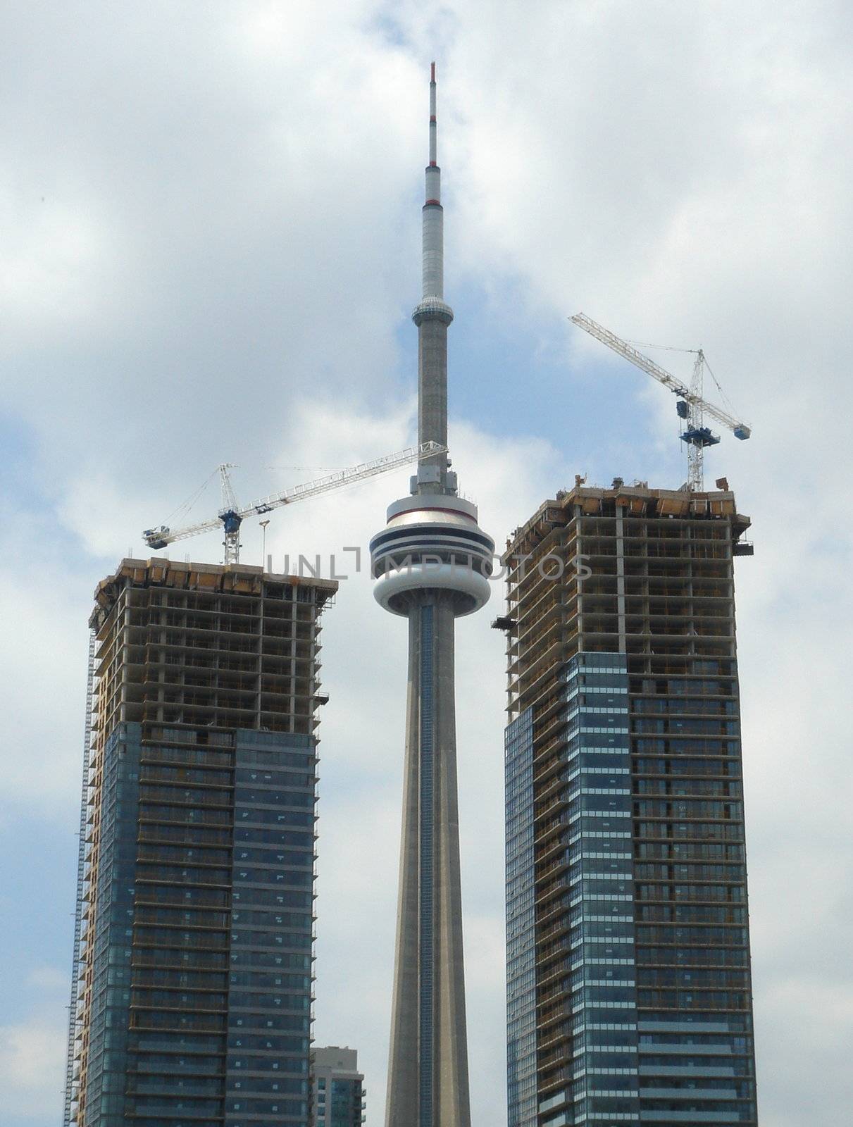 CN Tower of Toronto between two buildings in construction by Elenaphotos21