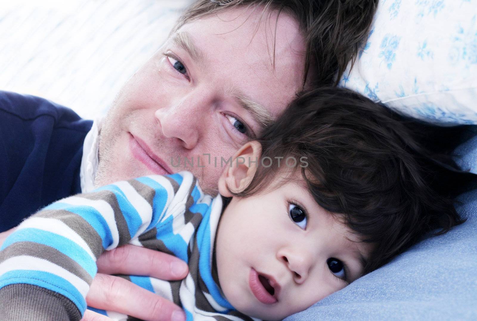 father and son resting in bed by jarenwicklund
