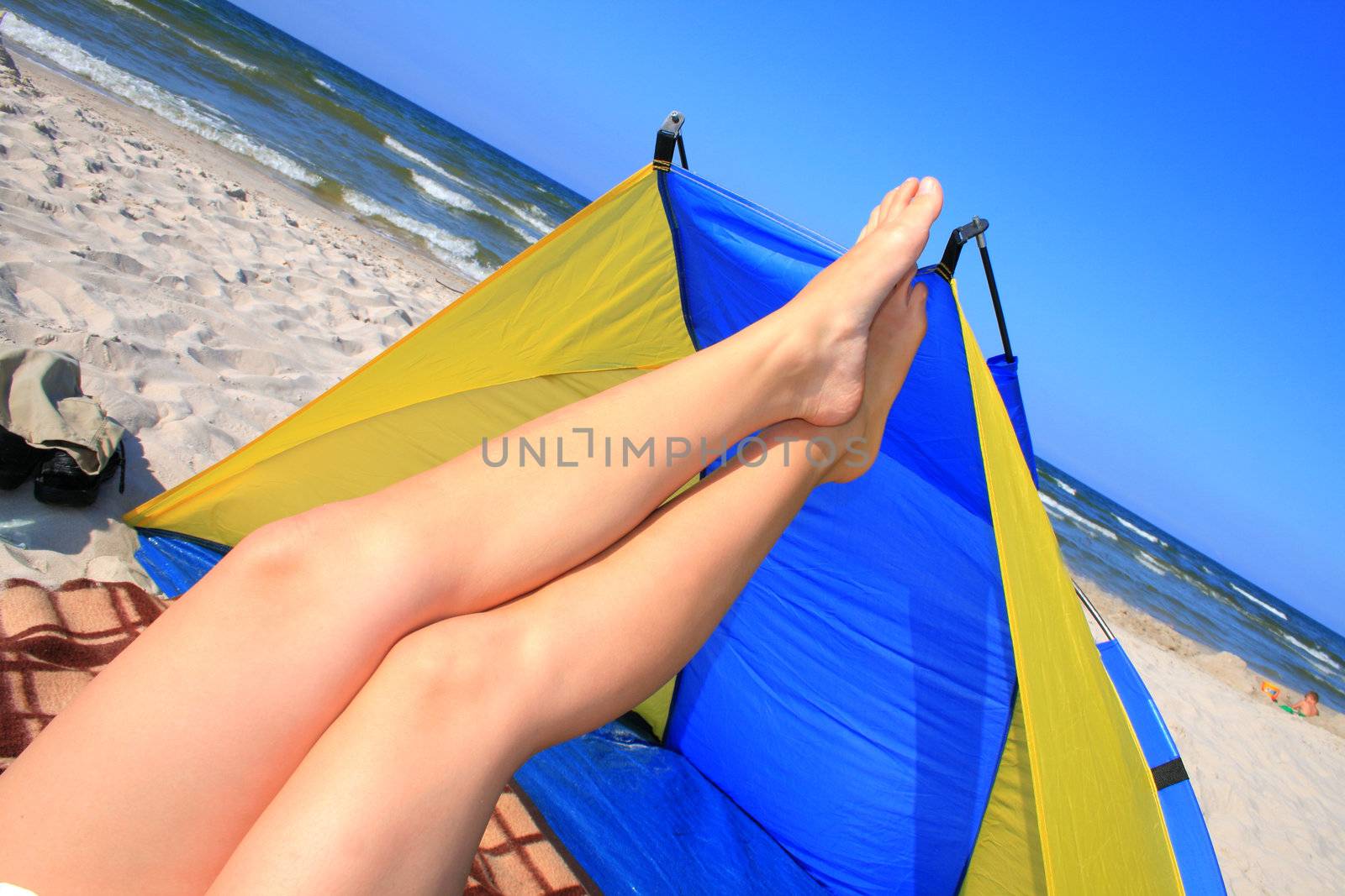 Beautiful woman with crossed legs resting on the beach
