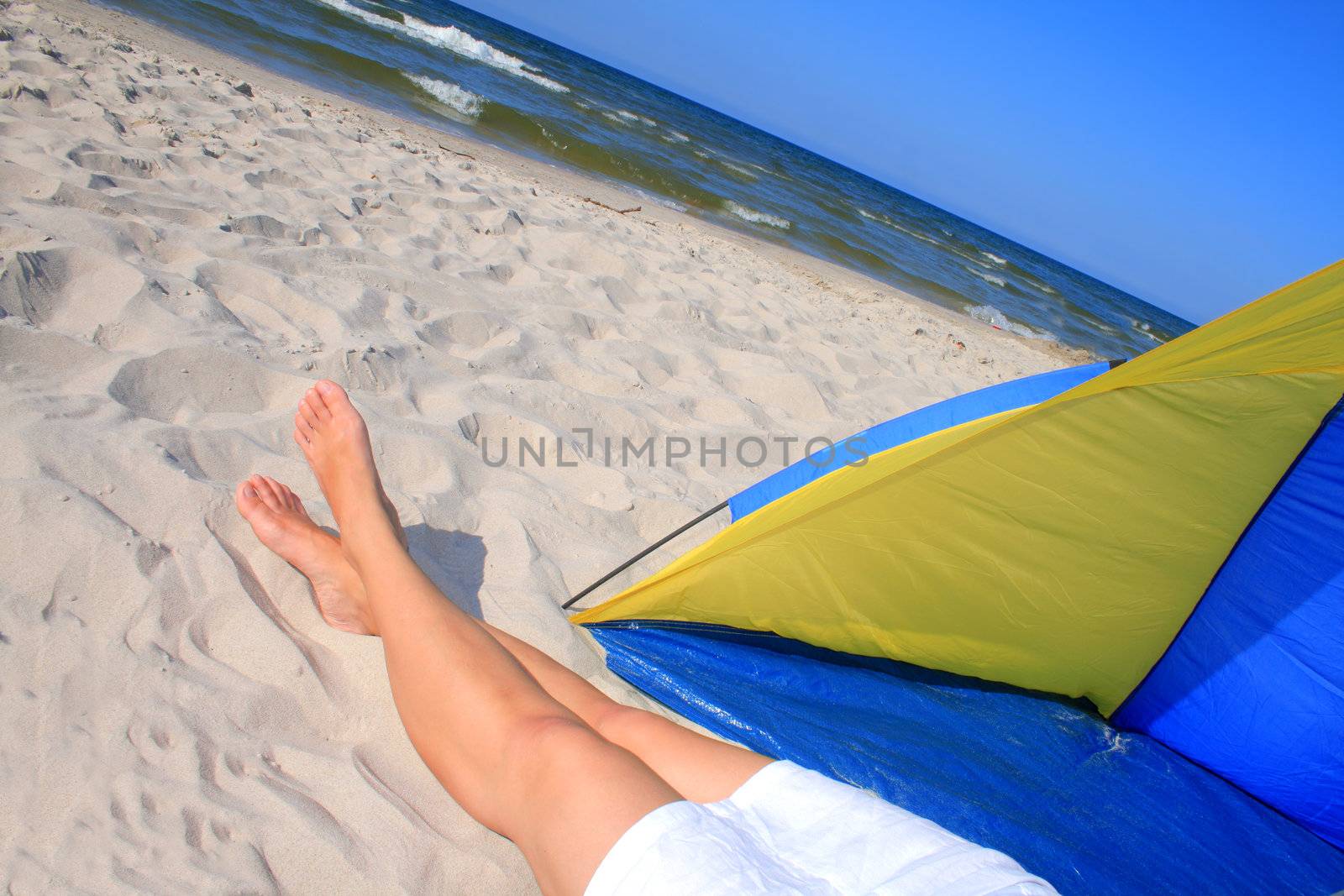 Woman in white skirt resting on the beach
