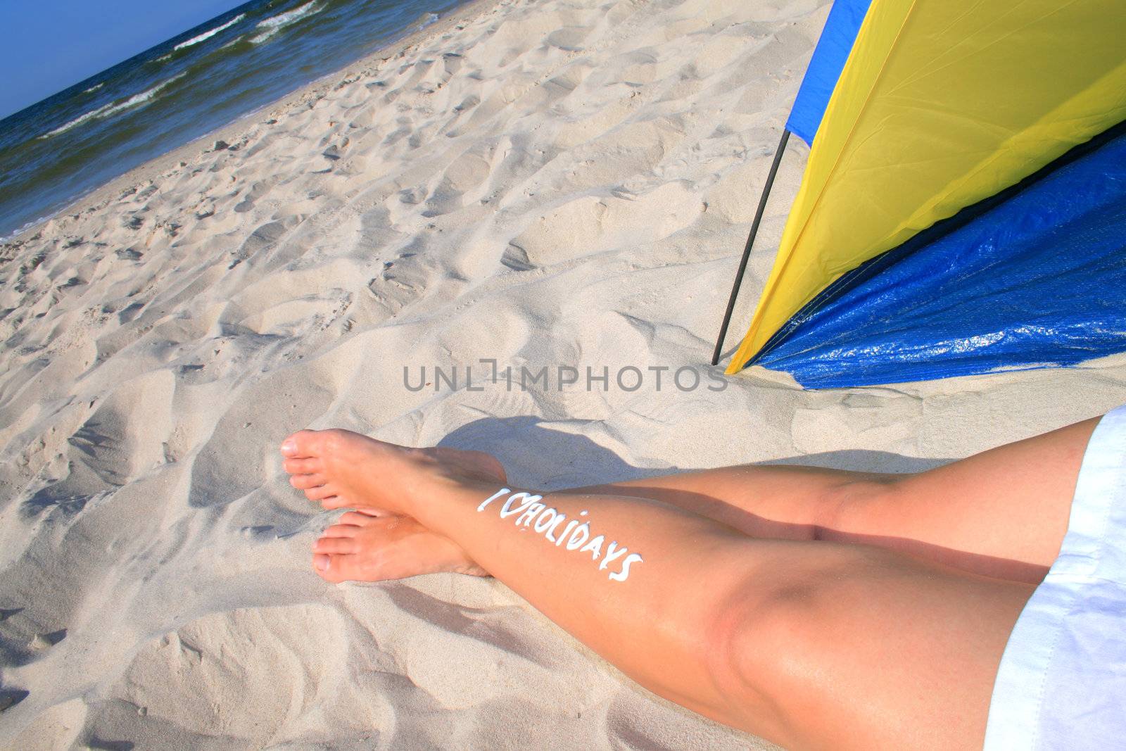 Woman with creamy sign I love holidays on her legs
