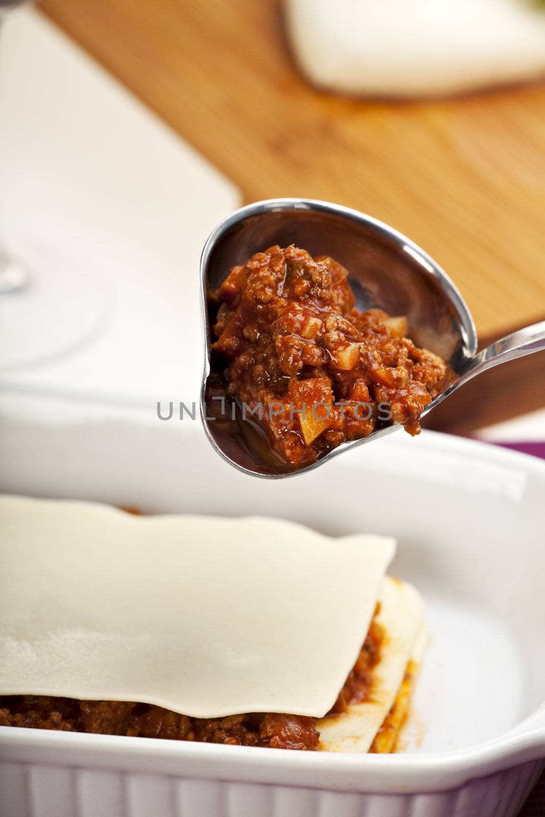 making a lasagna by pouring the sauce by bernjuer