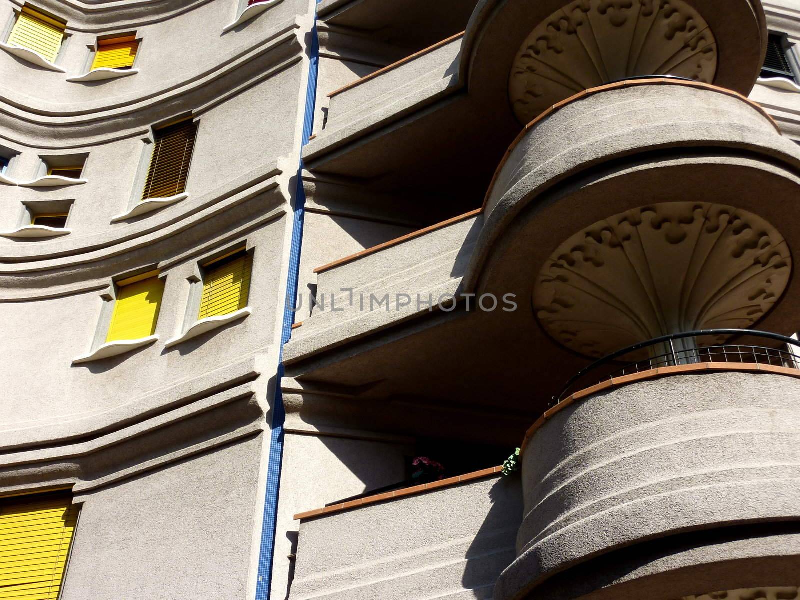 Detail of balconies on an eccentric facade with yellow shutters