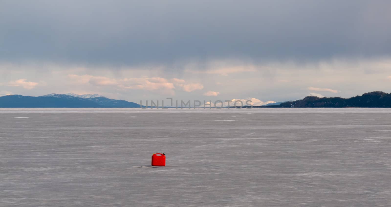 Red jerry-can full of gasoline on vast frozen Lake Laberge, Yukon Territory, Canada