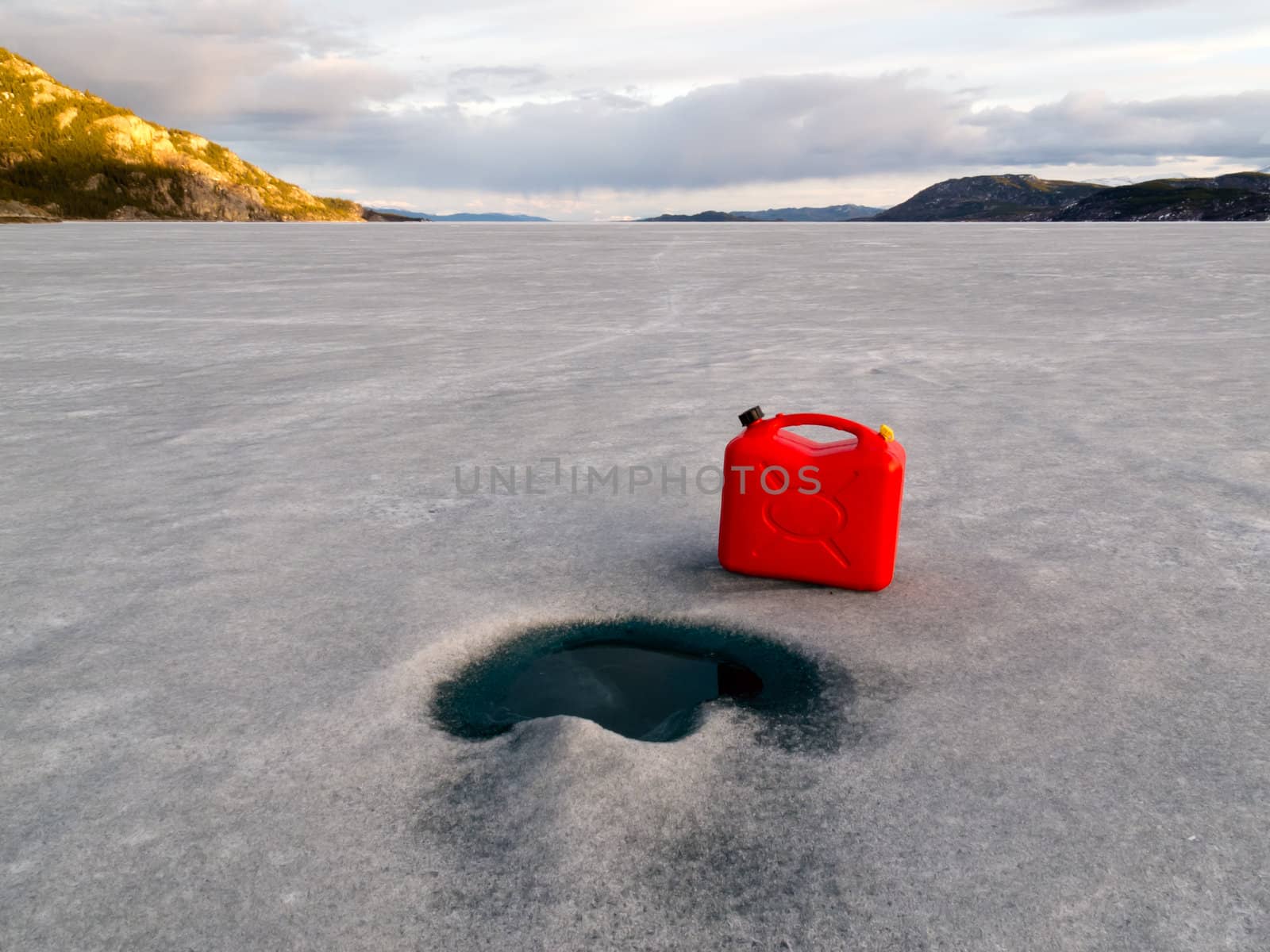 Red jerry-can full of gasoline on vast frozen Lake Laberge, Yukon Territory, Canada