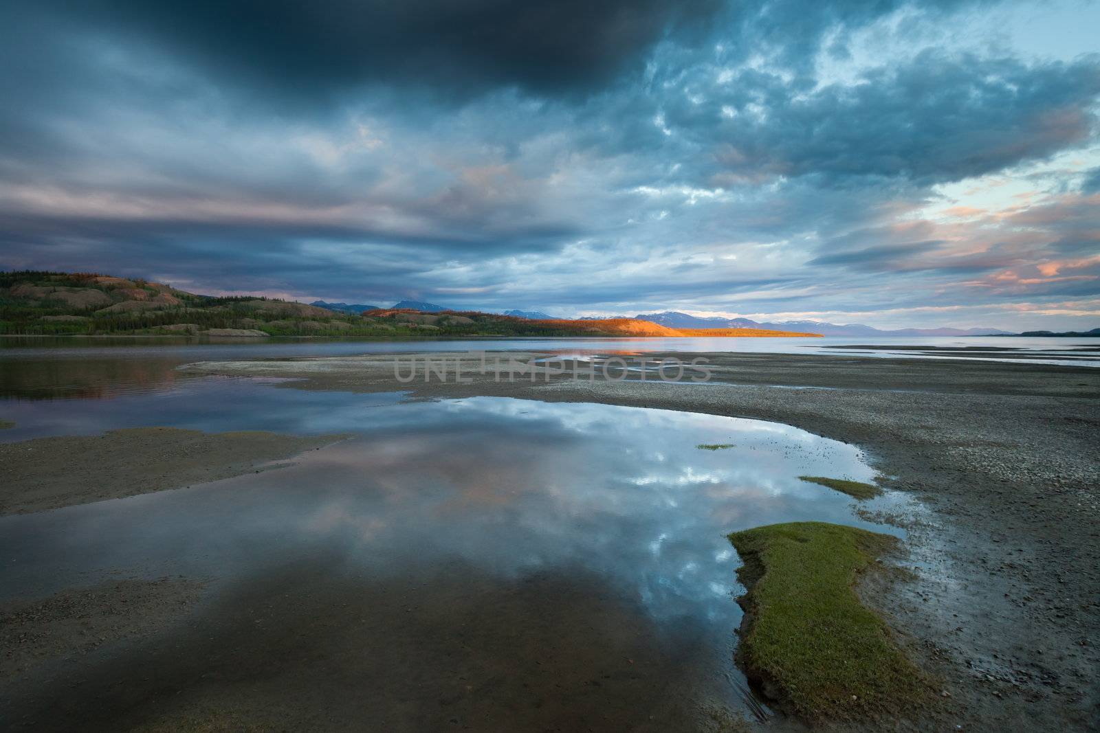 Dramatic Cloudscape and distant sunbeam at Lake Laberge, Yukon Territory, Canada