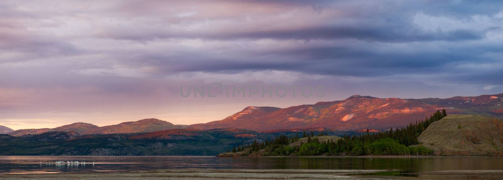 Distant mountains glowing in sunset light at Lake Laberge, Yukon Territory, Canada.