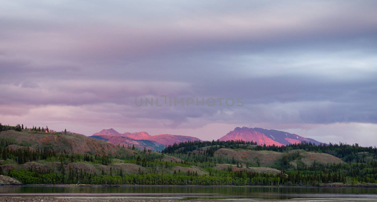Distant mountains glowing in sunset light  at Lake Laberge, Yukon Territory, Canada.
