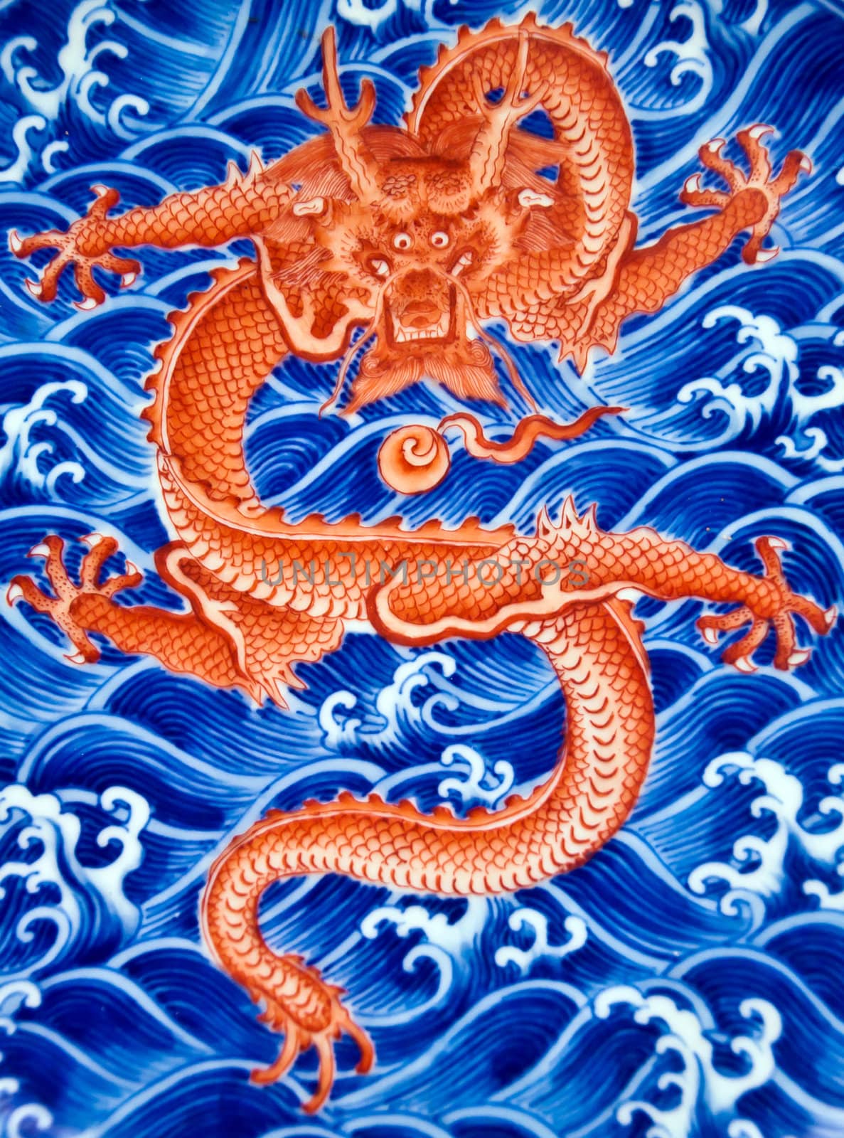 Chinese red dragon on blue water, decoration of a ming plate