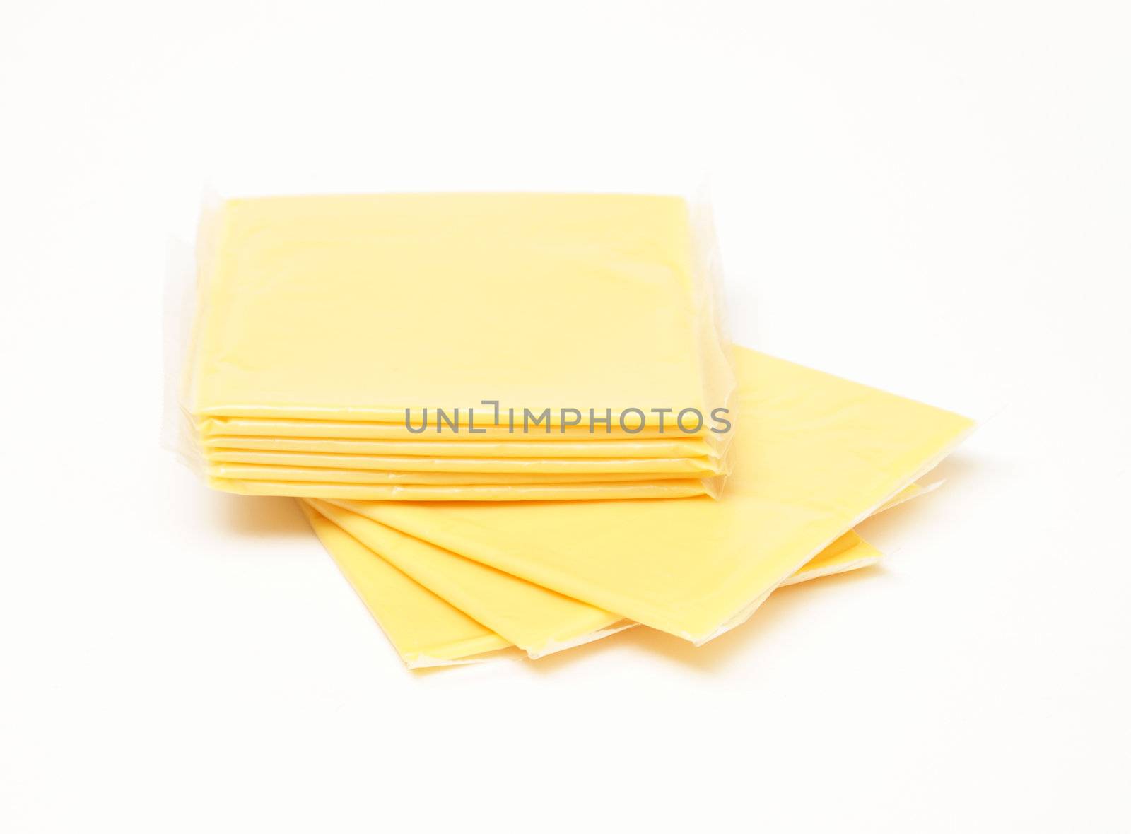 A stack of processed cheese slices over white background.