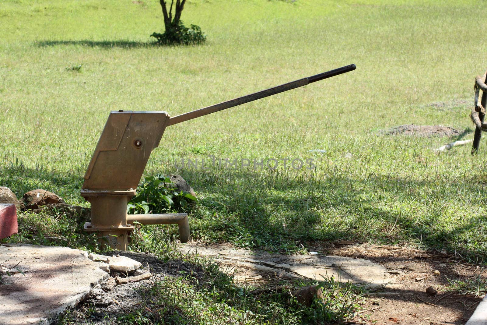 An old rusted water hand pump on an underground well in an Indian village.
