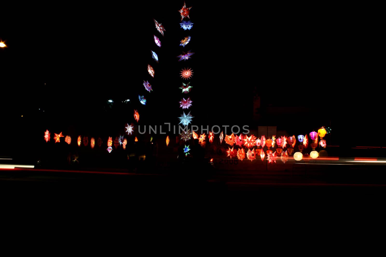 Lanterns lit up on the occasion of Diwali festival India on the side of a busy street. The logos on the lantern are not trademarks but images of hindu goddesses.