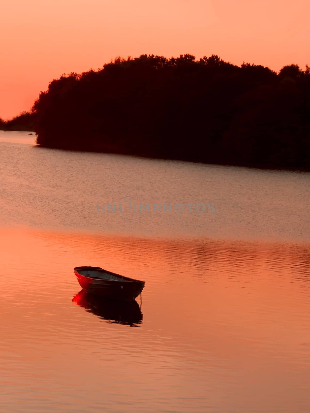 Anchored boat in the reservoir after sunset in quiet summer weather. Khmelnitsky, Ukraine