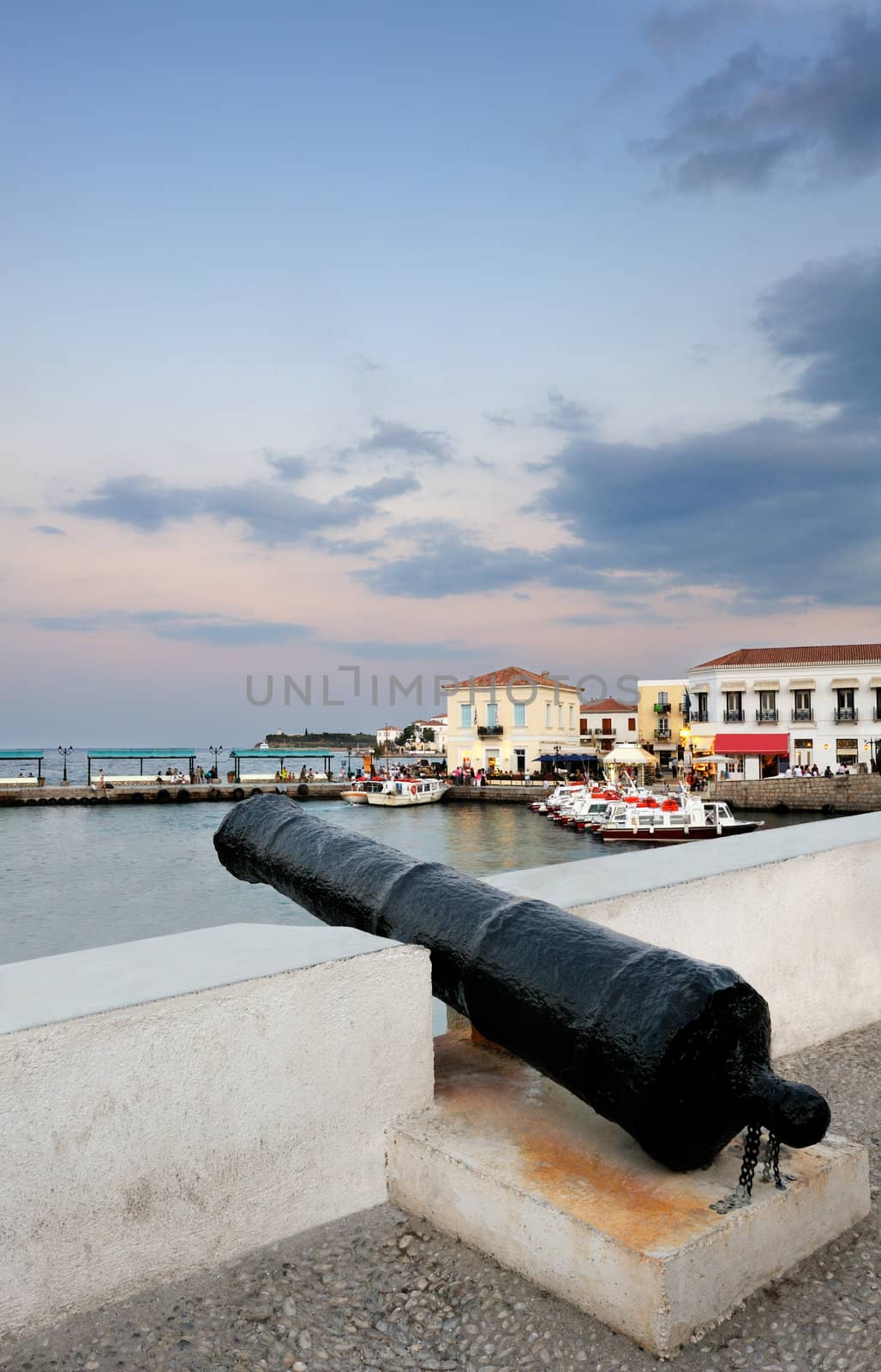 An old cannon pointing at the new harbour on the island of Spetses, Greece