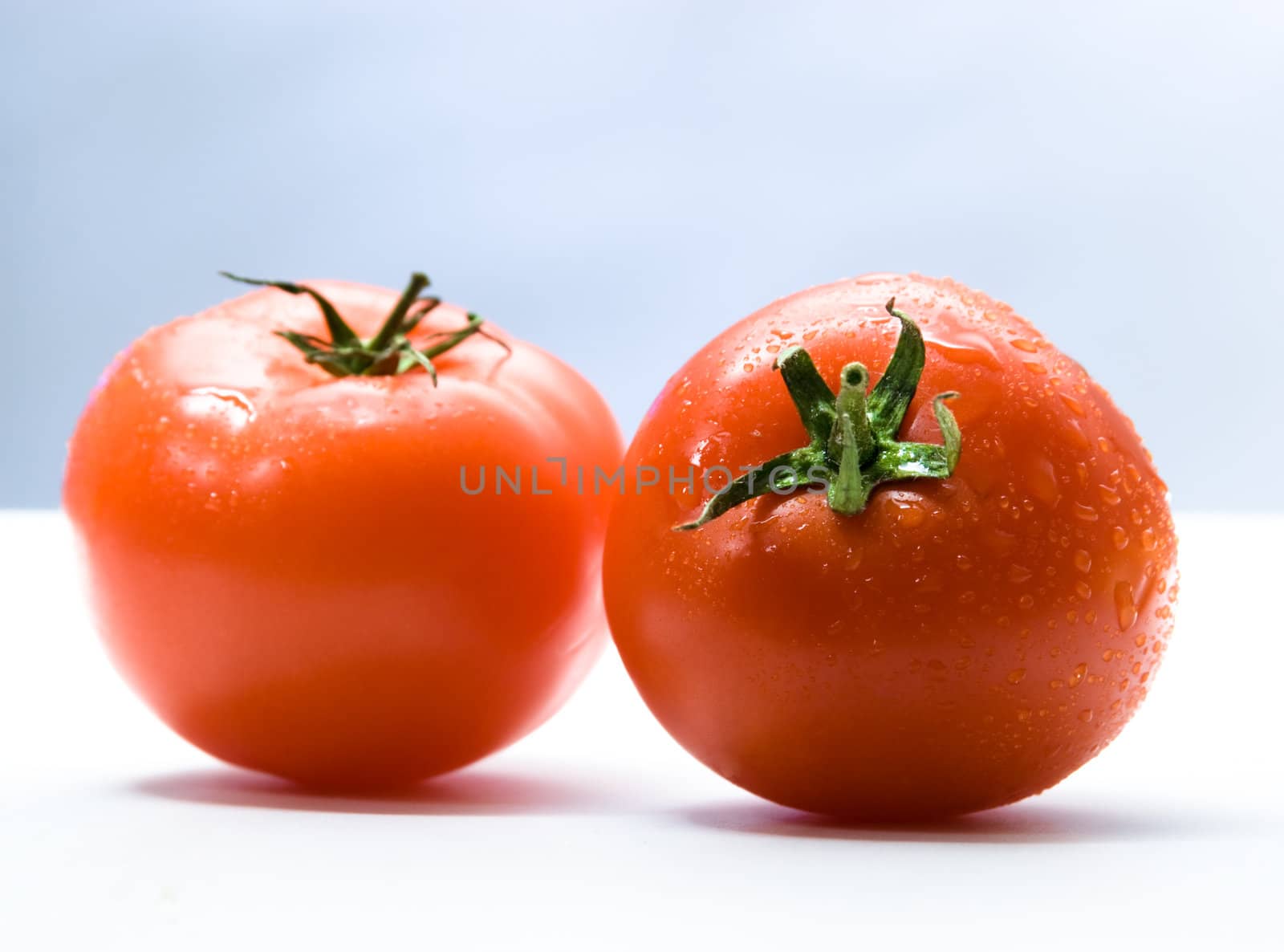 Two tomatoes with drops.