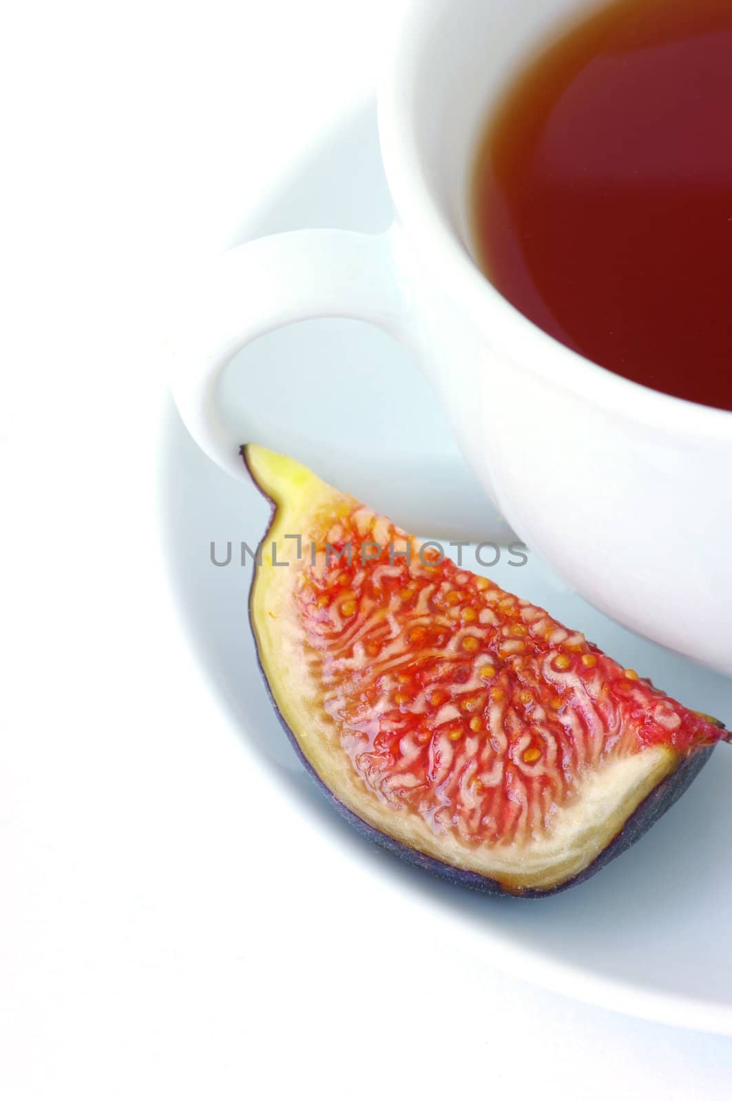 Tea cup and fig fruit on a white background