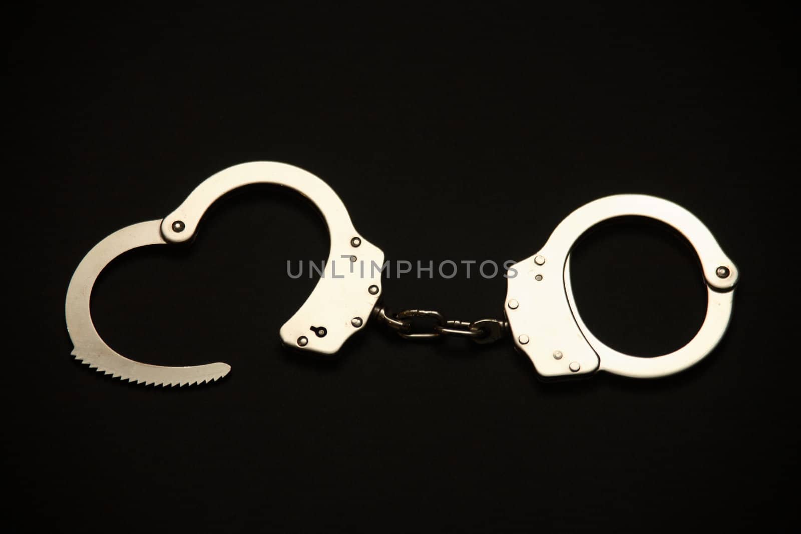 A pair of open handcuffs.