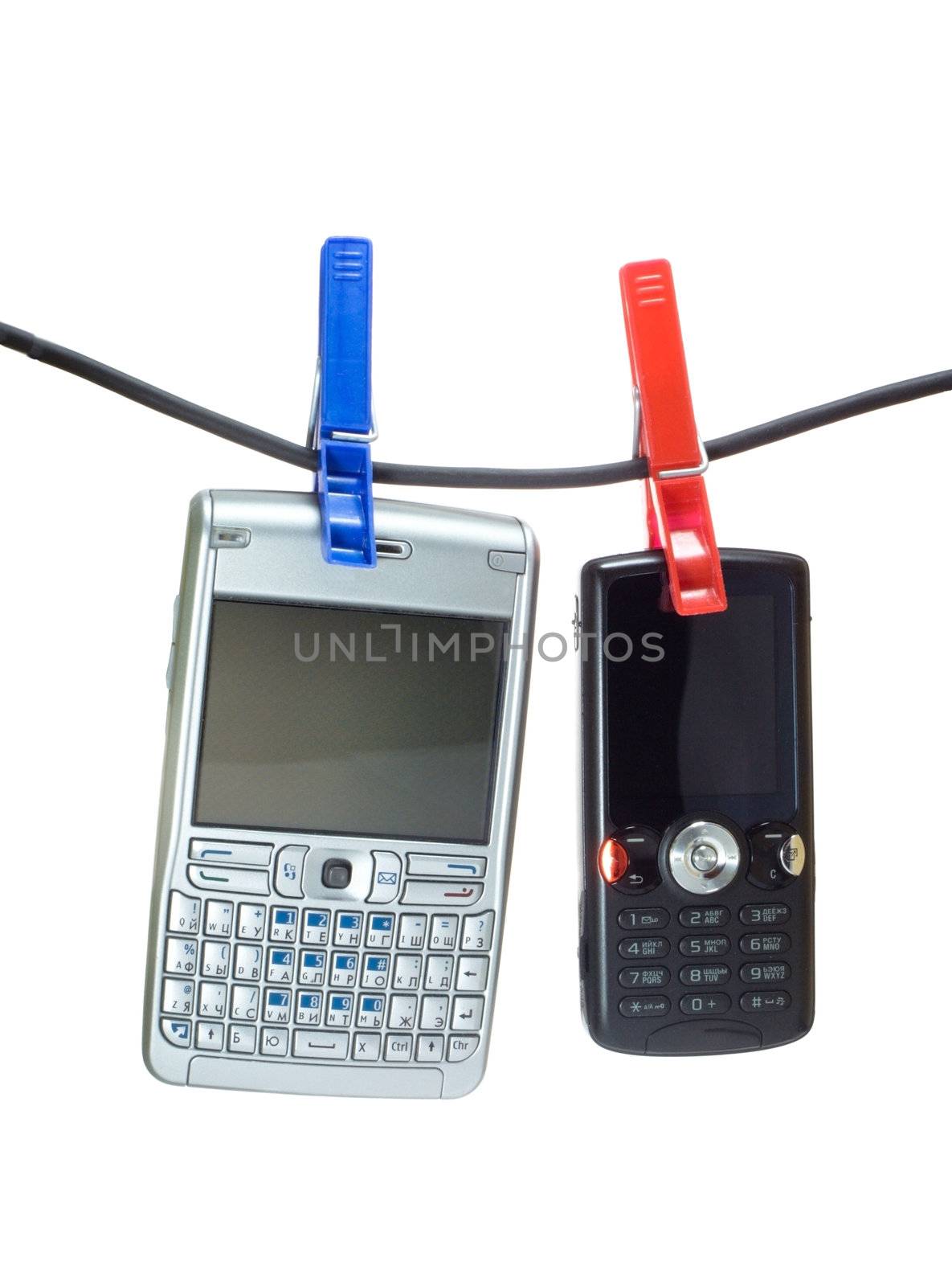 Two mobile phones on a clothes line, hanging with clothes-peg
