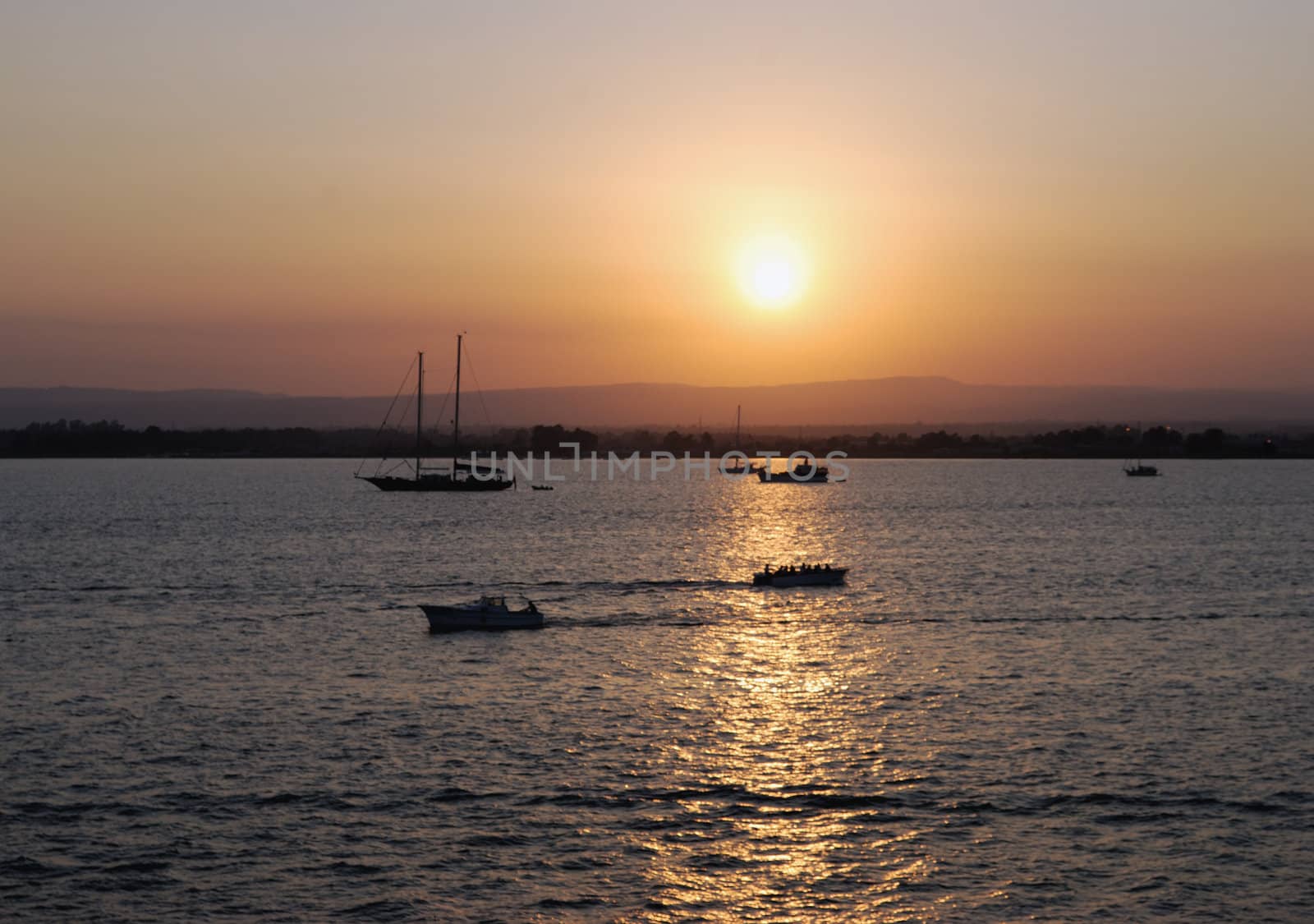 Ortigia island city of Siracusa (Italy) sunset with boats