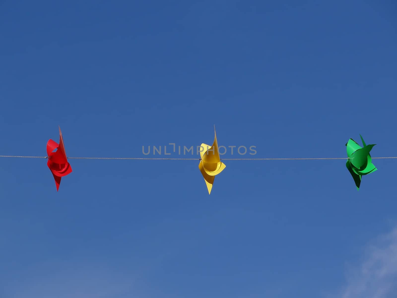 red yellow and green windmill in front of blue sky