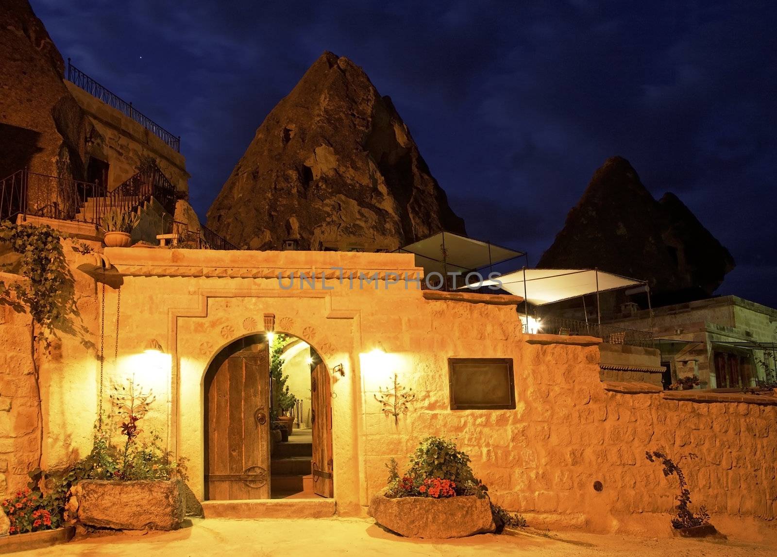Limestone cave residence converted to a boutique hotel Goreme, Turkey. Night scene under street lights, horizontal landscape with crop area and copy space