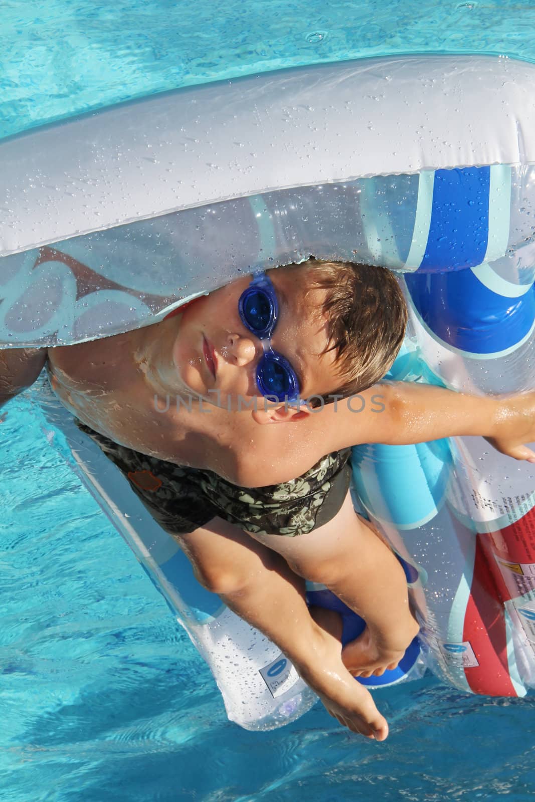 little young boy on air matress in swimming pool