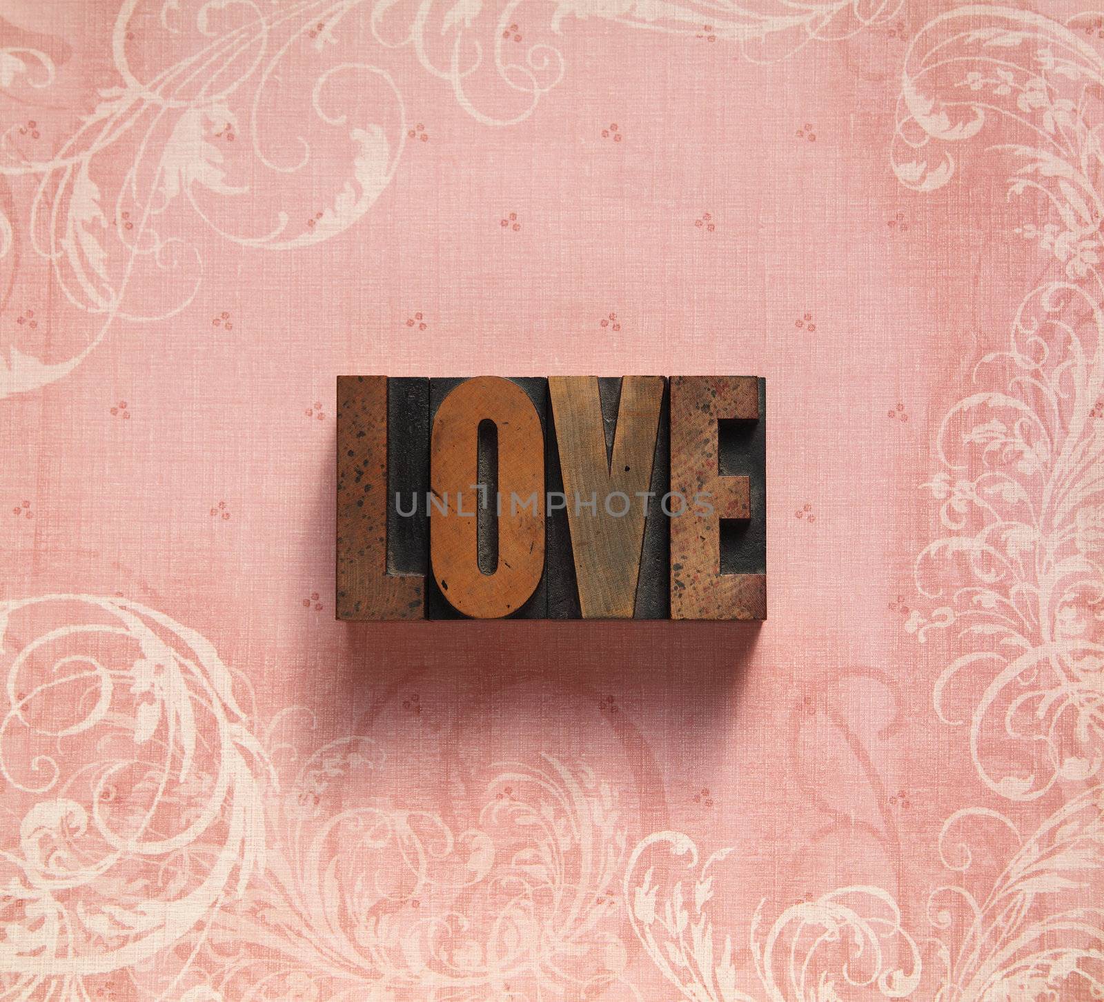 the word 'love' on a pale pink background with decorative swirls