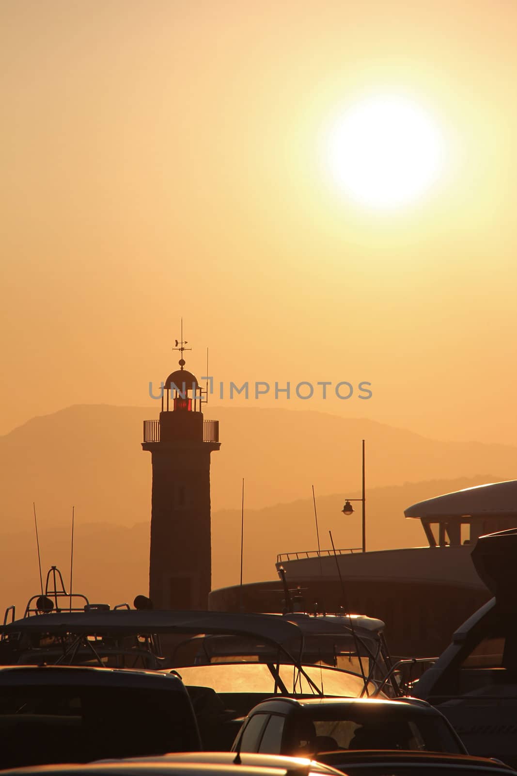 Lighthouse of saint tropez with ships in sunset