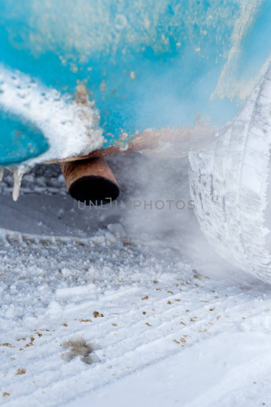 Exhaust pipe of idling car in cold winter conditions.
