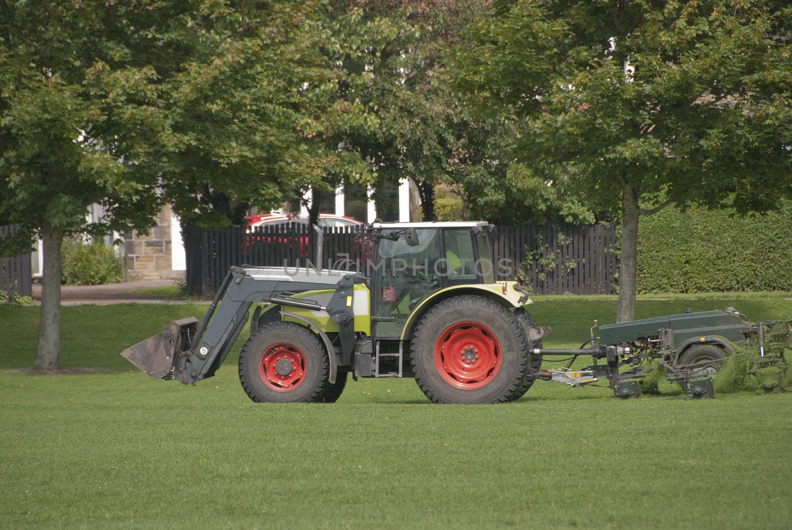 A Tractor Mowing Grass in a Park