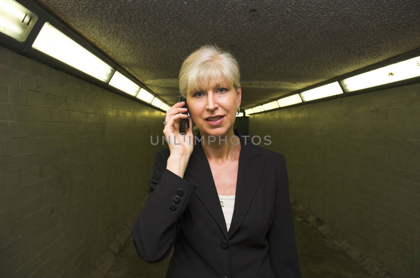 Mature business woman on mobile phone in urban setting.