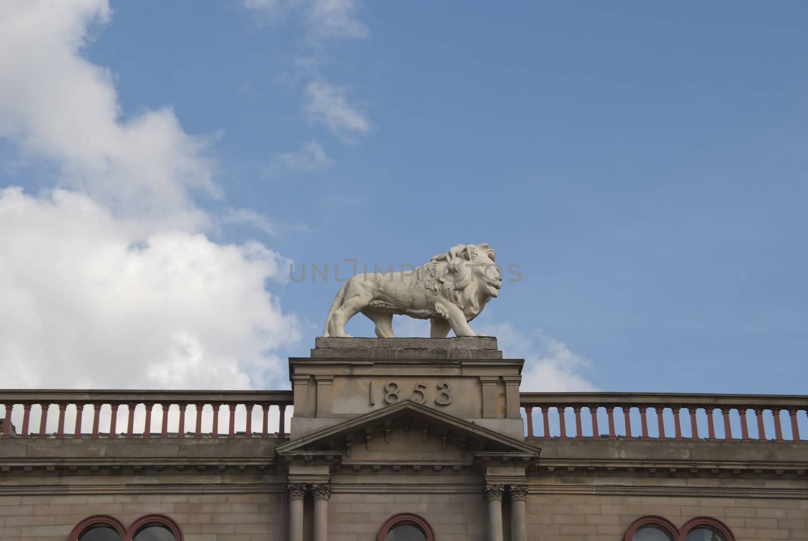 Statue of a White Lion on top of a Victorian Building signifying pride and achievement