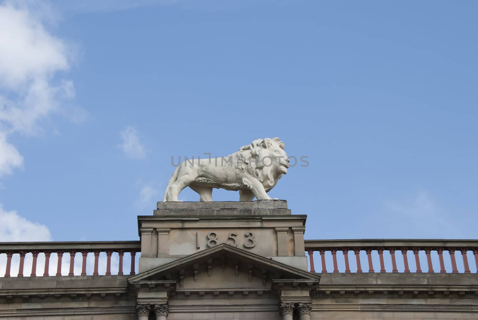 Statue of a White Lion on top of a Victorian Building signifying pride and achievement