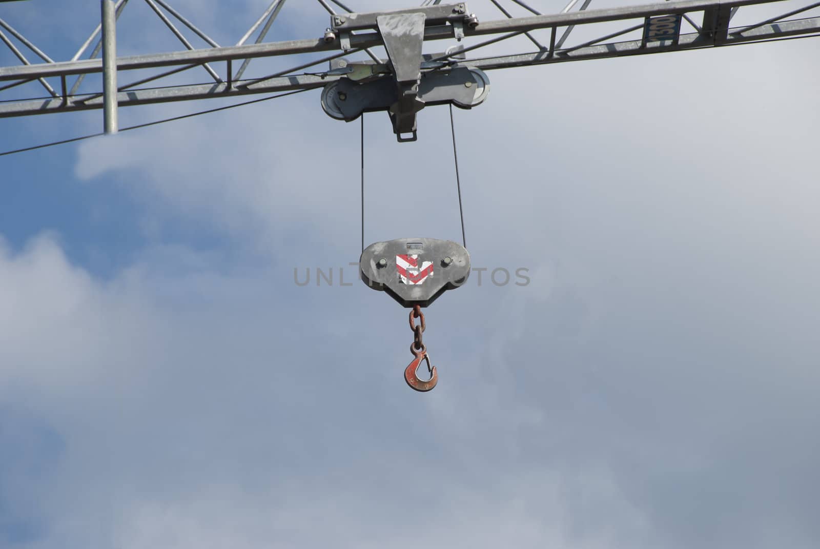 A Construction Crane Hook against a cloudy sky