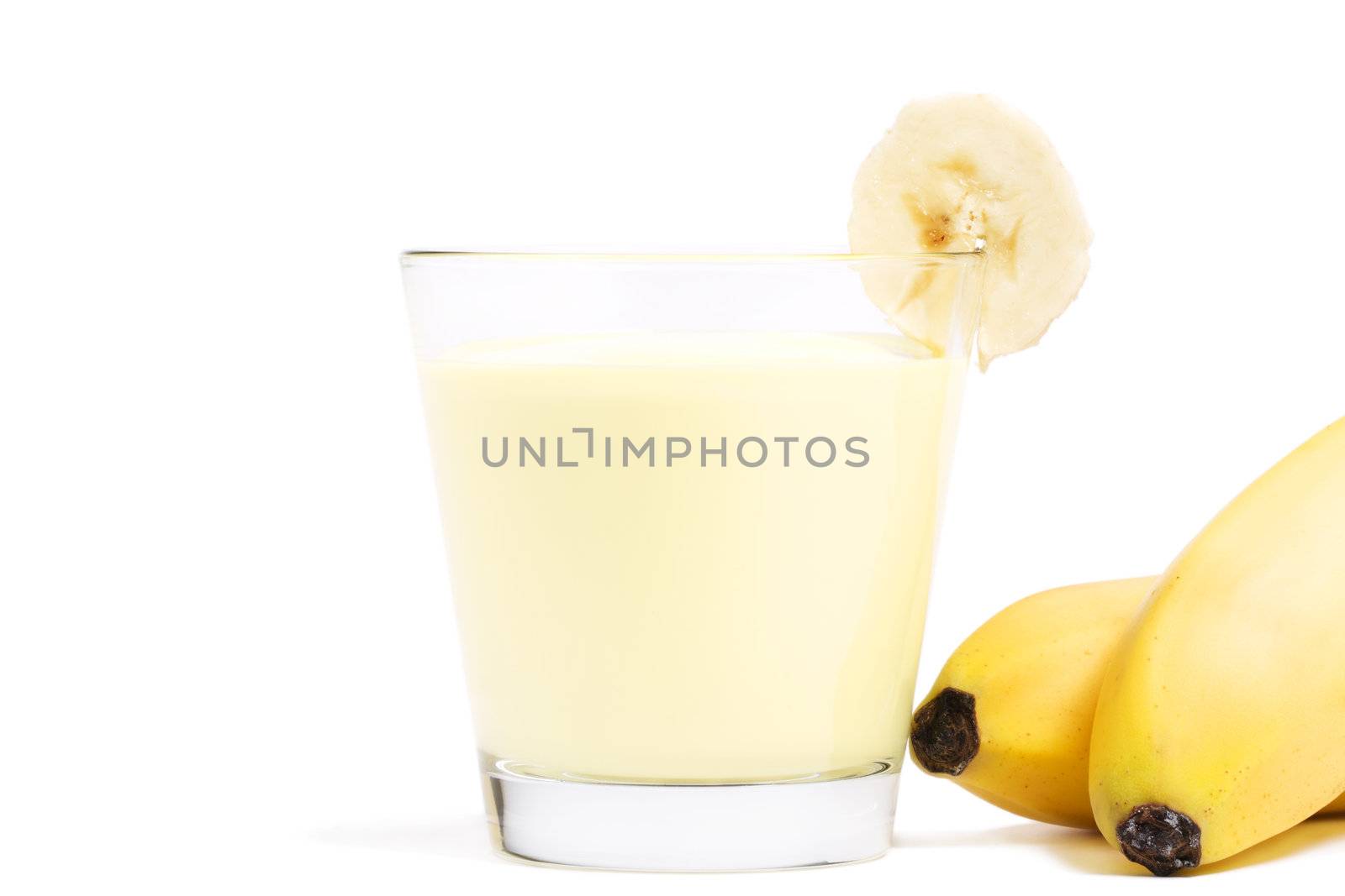 banana milkshake with a piece of banana and bananas aside on white background