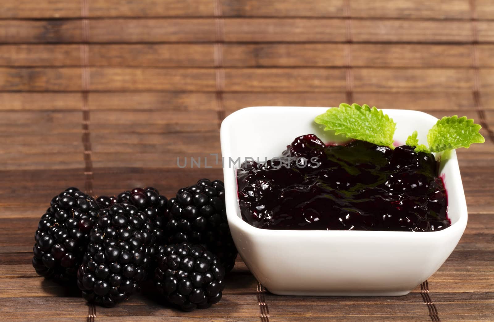blackberry jam and blackberries on wooden background