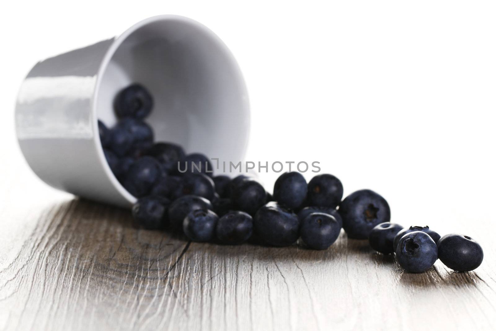 blueberries rolling from a fell over cup by RobStark