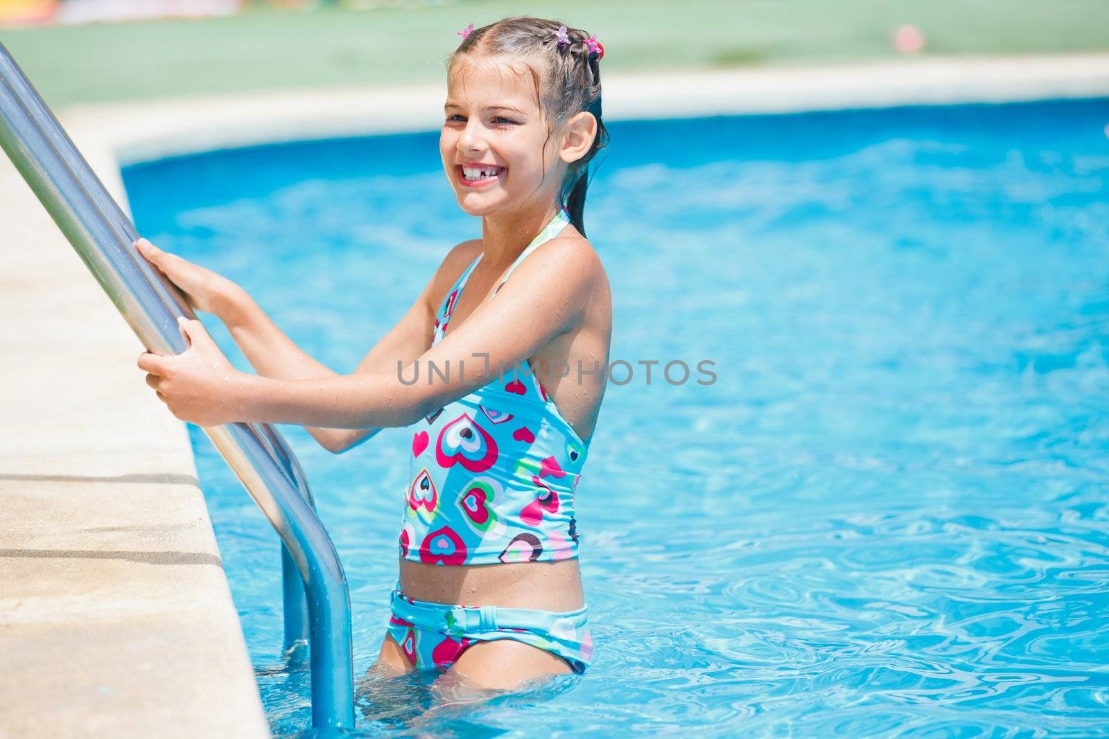 Pretty young girl stay at pool's edge